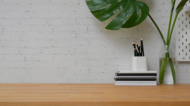Ofis malzemeleriyle modern çalışma alanını kapatın ve tuğla duvar arkaplanlı ahşap masa üzerindeki alanı kopyalayın. 