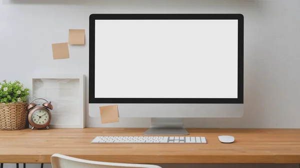 Закрыть вид на макет настольного компьютера с причудливой запиской и украшением на деревянном столе на белом фоне стены — стоковое фото