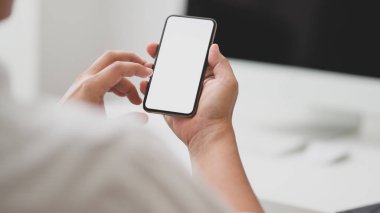 Bulanık ofis odasıyla boş ekran akıllı telefon yazan işadamı görüntüsü.