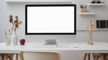 Çalışma alanını boş ekran bilgisayar, ofis malzemeleri, dekorasyon ve beyaz duvarlı rafla kapat  