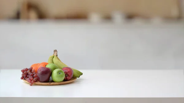 Abgeschnittene Aufnahme von Obstschale und Kopierraum auf Marmorschreibtisch mit verschwommenem Küchenraum — Stockfoto
