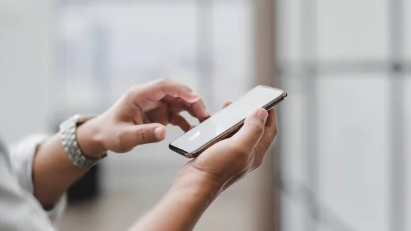 Close-up vista de empresário tocando smartphone tela em branco com fundo sala de escritório borrada — Fotografia de Stock