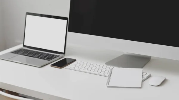 Captura recortada de espacio de trabajo con computadora portátil de pantalla en blanco, computadora, teléfono inteligente y portátil en la mesa blanca —  Fotos de Stock