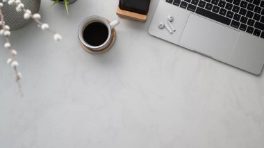 Çalışma alanı, fotokopi alanı, ofis malzemeleri, dekorasyon ve kahve fincanı mermer masanın üzerinde.