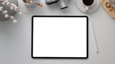 Boş ekran dizüstü bilgisayarı, boya fırçası, dekorasyon ve beyaz masadaki kamera ile işyerinin üst görüntüsü 