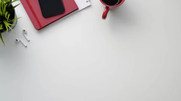 Top view of workspace with copy space, office supplies, wireless headphone and coffee cup on marble desk