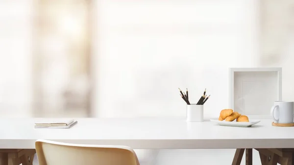 Vue rapprochée de l'espace de travail avec espace de copie, cadre, papeterie, tasse à café et croissant sur table blanche avec flou — Photo