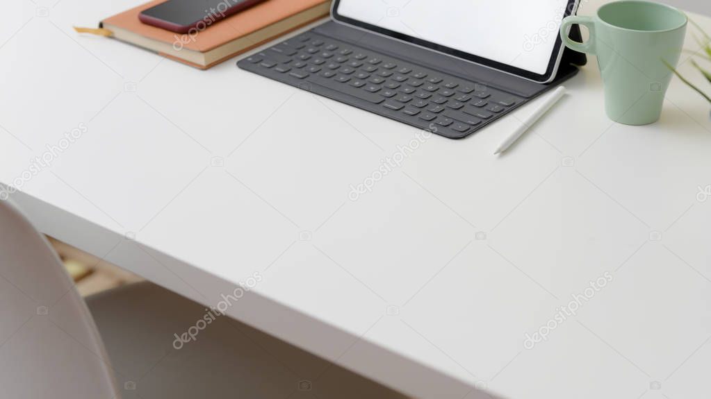 Close up view of workspace with copy space, mock up laptop, coffee cup, smartphone and office supplies 