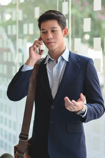Vista de cerca del hombre de negocios hablando en su teléfono inteligente en el fondo borroso de la sala de reuniones — Foto de Stock