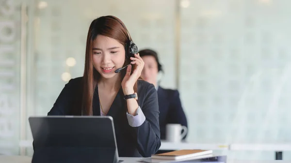 Nahaufnahme einer Kundin, die lächelnd auf dem Headset spricht — Stockfoto