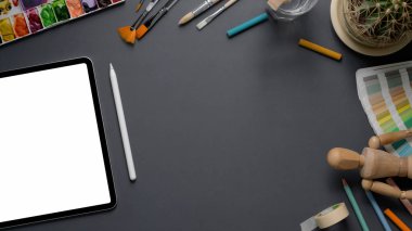 Tablet, stil, boyama araçları ve gri masa arkaplanındaki kopyalama alanı ile tasarımcı çalışma alanının genel görüntüsü  