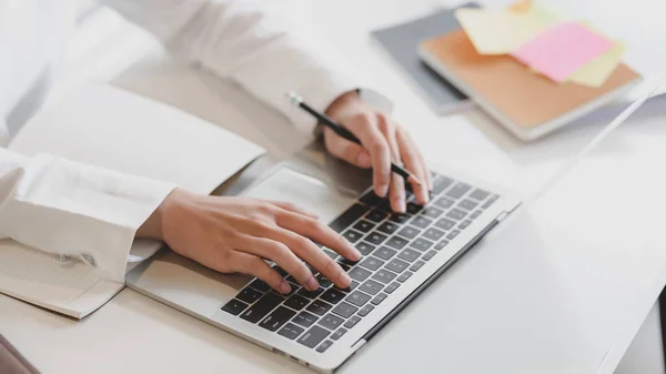 Przycięte zdjęcie bizneswoman pracującej na laptopie i notebooku z materiałami biurowymi na białym stole — Zdjęcie stockowe