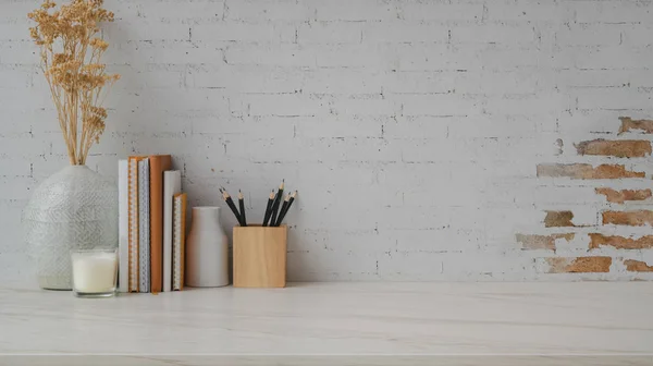 Captura recortada de espacio de trabajo contemporáneo con espacio de copia, decoraciones, lápices y libros sobre escritorio de mármol con fondo de pared de ladrillo —  Fotos de Stock