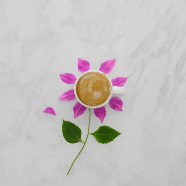 Flache Kaffeetasse mit rosa Blütenblättern, Blätter auf Marmorhintergrund — Stockfoto