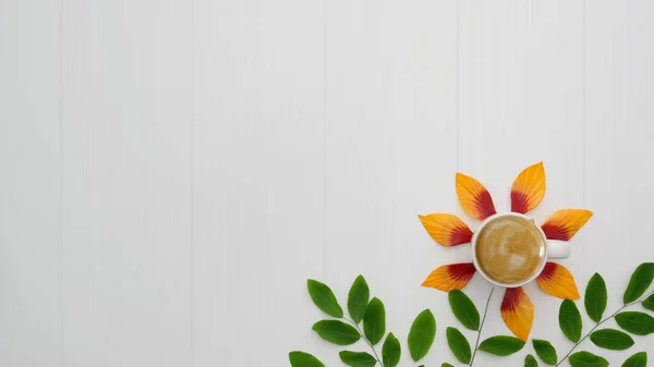 Draufsicht auf Kaffeetasse mit orangefarbenen Blütenblättern, Blätter im Raum auf Plankenhintergrund — Stockfoto