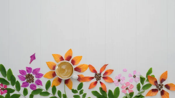 Draufsicht auf Kaffeetasse mit Blütenblättern, Blätter auf weißem Plankenhintergrund — Stockfoto