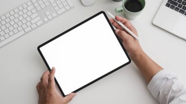 İşadamı uygulamalı çalışma alanında bilgisayar ve dizüstü bilgisayarla tablet üzerinde çalışırken üst görünüm