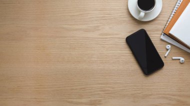 Akıllı telefon, fotokopi alanı, kahve fincanı ve ahşap masa arkasındaki ofis malzemelerinin bulunduğu en iyi çalışma alanı.