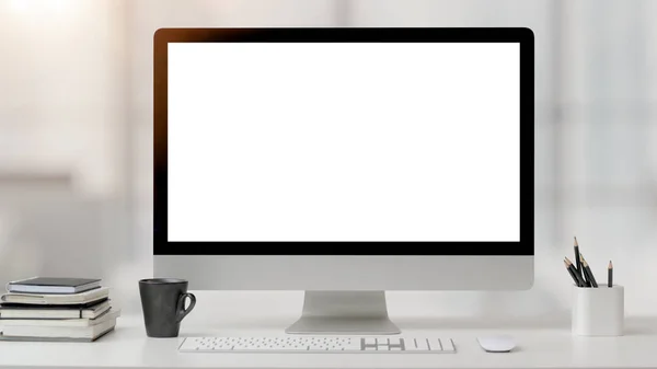 Ofis odasını bilgisayarla, ofis malzemeleriyle ve arka planı bulanık beyaz masadaki kahve fincanıyla kapatın.