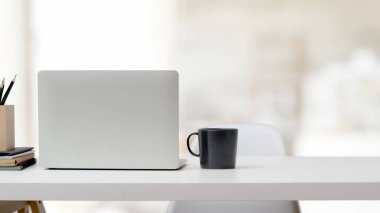 Çalışma alanını laptopla, ofis malzemeleriyle, kahve bardağıyla ve beyaz masadaki boşluğu kopyalayarak kapat 