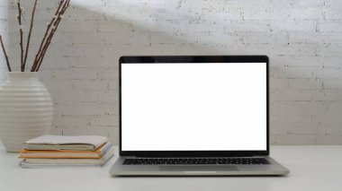 Dizüstü bilgisayarı, kitapları ve dekorasyonu olan basit iş yeri görünümünü kapat 