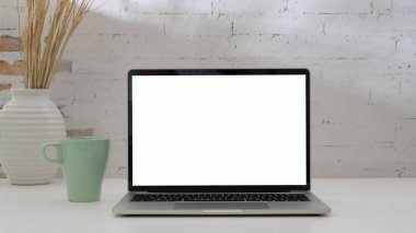 Laptop, kahve fincanı ve beyaz masa dekorasyonuyla basit iş yeri manzarasını kapat 