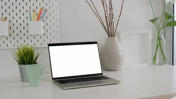 Captura recortada de espacio de trabajo mínimo con computadora portátil de pantalla en blanco, taza de café y decoraciones —  Fotos de Stock