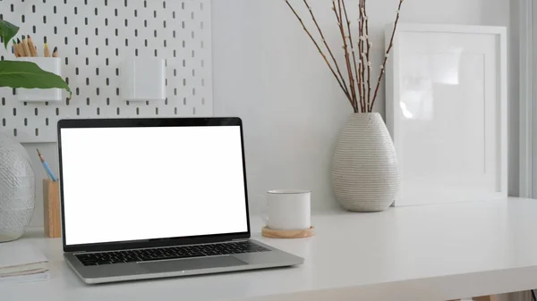 Ritagliato colpo di spazio di lavoro moderno con computer portatile schermo vuoto, modello su telaio e vaso in ceramica su tavolo bianco — Foto Stock