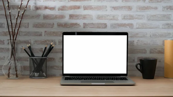Vista de perto do espaço de trabalho contemporâneo com laptop tela em branco, papelaria, xícara de café e decorações — Fotografia de Stock