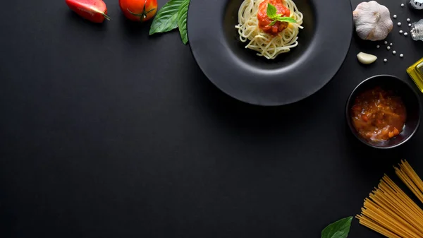 Bovenaanzicht van spaghetti pasta met tomatensaus, ingrediënten en kopieer ruimte — Stockfoto