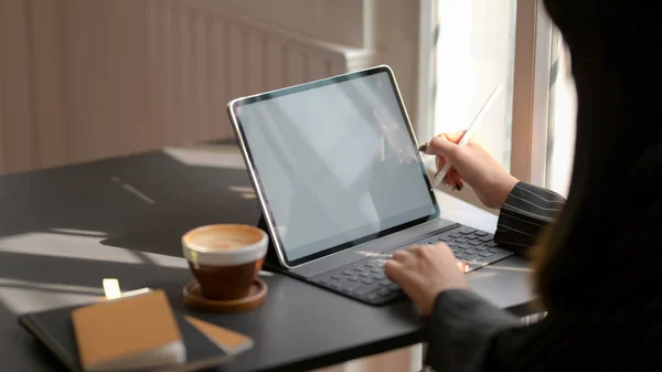 Abgeschnittene Aufnahme von Geschäftsfrauen, die an einem digitalen Tablet arbeiten, während sie in einem komfortablen Arbeitsbereich sitzen — Stockfoto