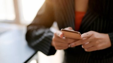 Rahat iş yerinde akıllı telefon kullanan bir kadının görüntüsünü kapat 