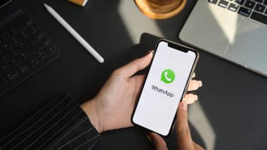 Chiang Mai, Tayland - 31 Ocak 2020: Whatsapp ekranlı iPhone tutan iş kadını. Whatsapp çok fonksiyonlu mesajlaşma uygulamasıdır