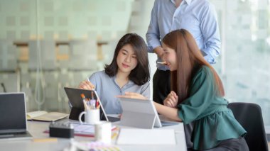 Close up view of application developer team brainstorming on their project with digital tablet in simple co working space