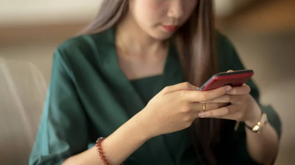 Recortado tiro de la mujer de negocios utilizando el teléfono inteligente en borrosa simple — Foto de Stock