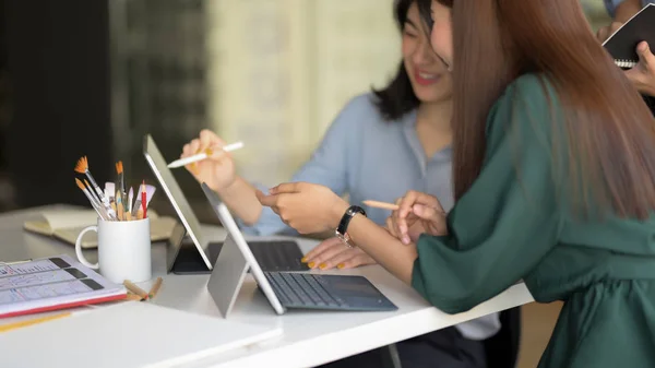 Side view of young professional designer team brainstorming on their project with digital tablet in simple co working space — Stockfoto