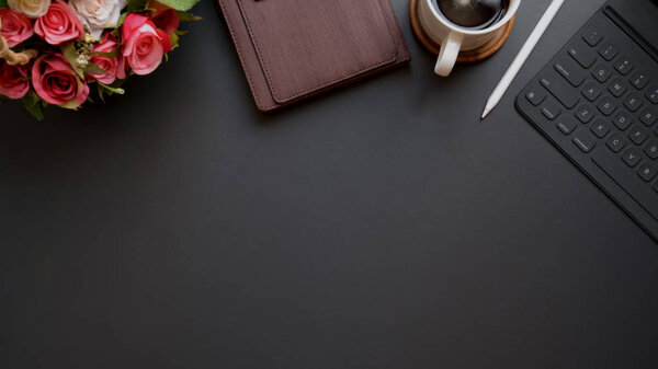 Снимок темного современного рабочего места с копировальным пространством на фоне черного стола
 