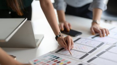 Close-up view of UI graphic designer team choosing the colour for their smartphone template 