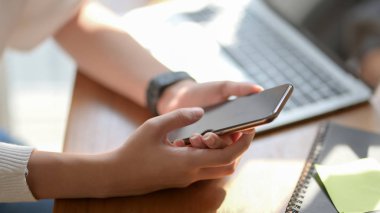 Akıllı telefondan projesi için fikir arayan üniversiteli bir kızın görüntüsü. 