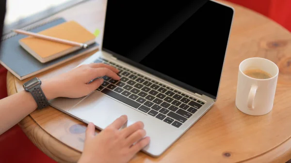 Vista de cerca de la joven universitaria escribiendo en el ordenador portátil mientras trabaja en su asignación en el espacio de trabajo conjunto —  Fotos de Stock