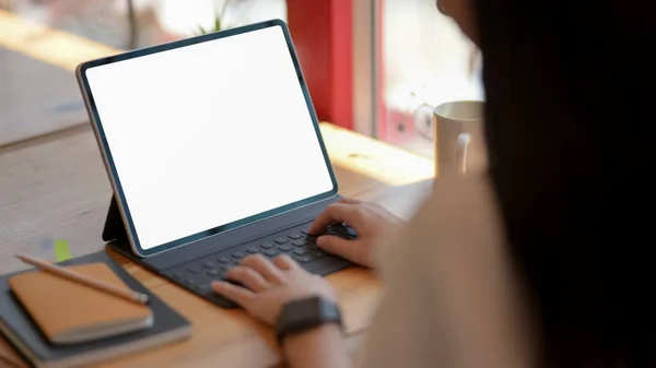 Nahaufnahme einer Studentin, die im Co-Working-Raum an ihrem Essay mit einem leeren Tablet arbeitet — Stockfoto
