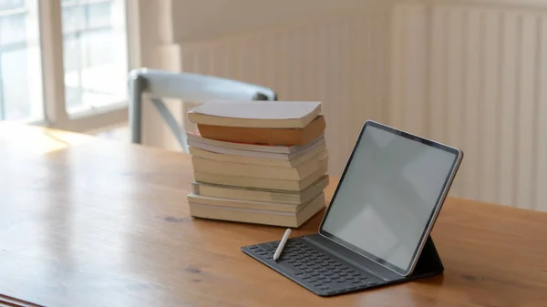 Tiro recortado de tablet tela em branco e livros sobre mesa de madeira em espaço de trabalho confortável — Fotografia de Stock