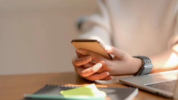 Close-up view of girl using her smartphone while sitting in co-working space — 图库照片