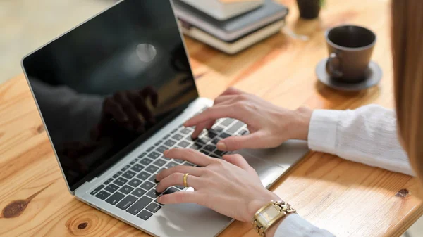 Gesneden foto van een vrouw typen op laptop op houten bureau — Stockfoto