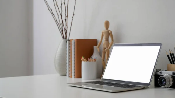 Cropped shot of workplace with blank screen laptop, camera  and decorations — Stock Photo, Image