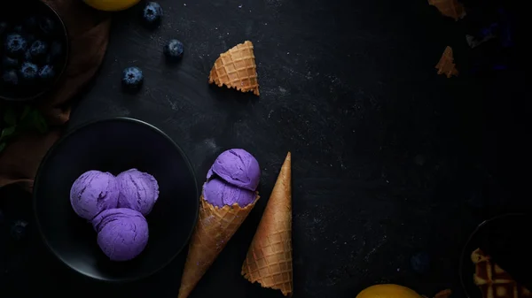 Overhead shot of summer dessert with blueberry flavour ice-cream on black desk background