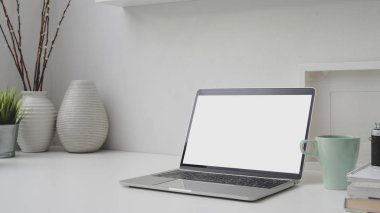 Boş ekran laptop, çerçeve, dekorasyon ve kopyalama alanı ile işyerinin kırpılmış görüntüsü 