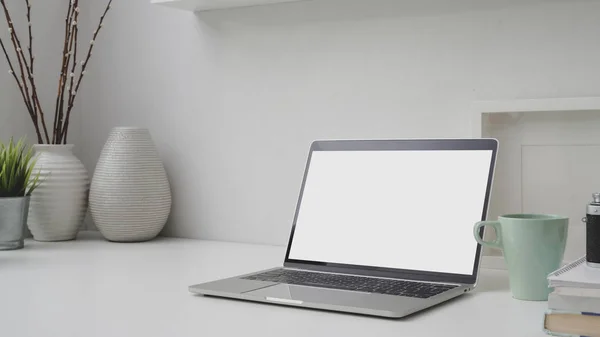 Captura recortada del lugar de trabajo con el ordenador portátil de pantalla en blanco, marco, decoraciones y espacio de copia —  Fotos de Stock