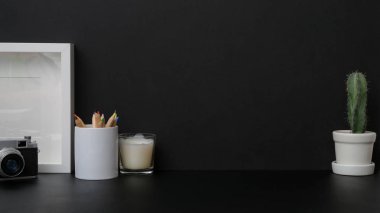 Siyah masa üzerinde çerçeve ile karanlık modern işyeri görünümünü kapat 