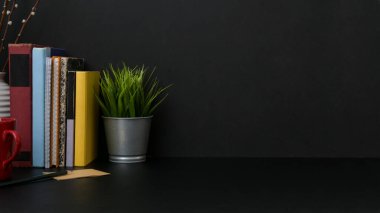 Siyah masa üzerinde mekan ve dekorasyonları olan karanlık ve modern işyeri görünümünü kapat 